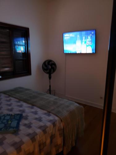 a bedroom with a bed and a flat screen tv at Pousada Monte Gerizim in Sao Paulo