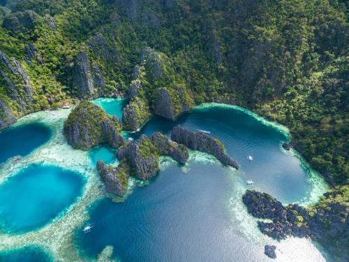 an aerial view of a beach with blue water at MyGuide Travellers Inn in Coron