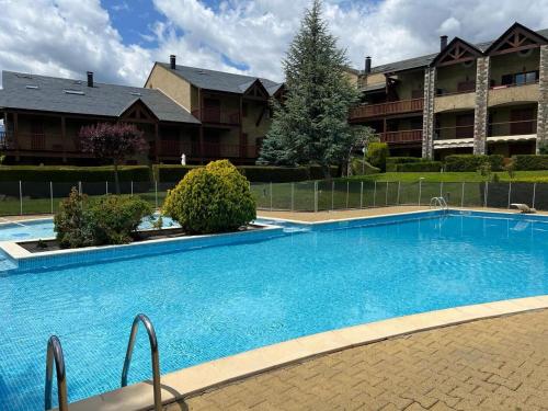 une grande piscine bleue devant un immeuble dans l'établissement Bourg Madame V Els Refugis, à Bourg-Madame