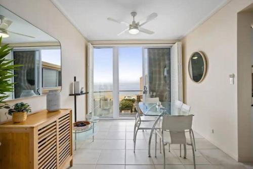 a dining room with a glass table and chairs at Beachside retreat with ocean views in Glenelg in Glenelg
