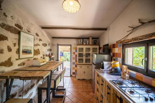 - une cuisine avec un comptoir et une cuisinière four supérieur dans l'établissement Plage de Furnellu location pieds dans l'eau, à Monacia-dʼAullène