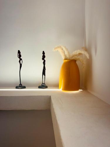 two figurines sitting on a shelf next to a pot at Villa Buon Vento in Vignacastrisi