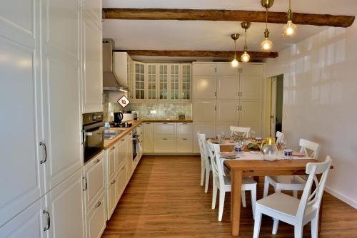 a kitchen with a wooden table and white cabinets at Douro Mool Guest House in Lamego