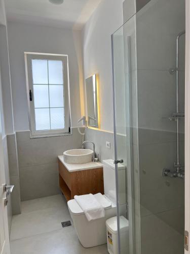 a bathroom with a toilet and a sink and a shower at Trevi Hotel & Restorant, Shengjin in Shëngjin