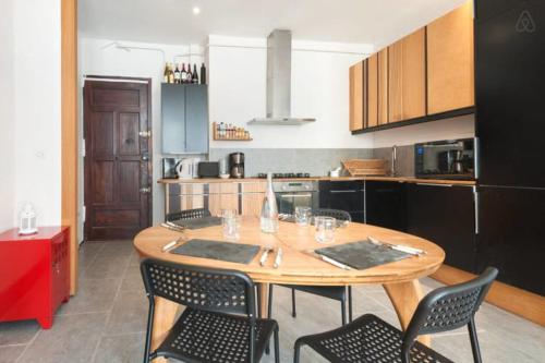 Il comprend une cuisine avec une table et des chaises en bois. dans l'établissement GuestReady - Part Dieu Parisian Base, à Lyon