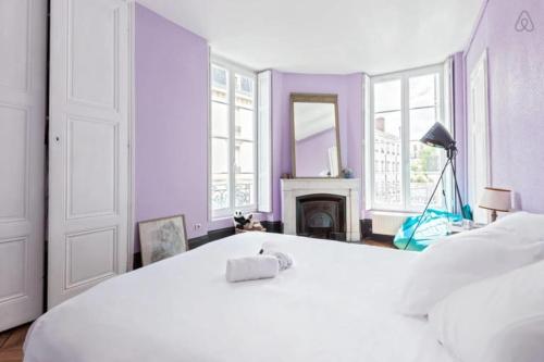 - une chambre blanche avec un lit blanc et une cheminée dans l'établissement GuestReady - Part Dieu Parisian Base, à Lyon