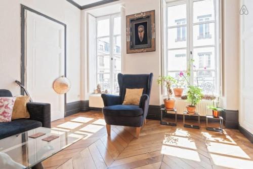 un salon avec un canapé, des chaises et des fenêtres dans l'établissement GuestReady - Part Dieu Parisian Base, à Lyon