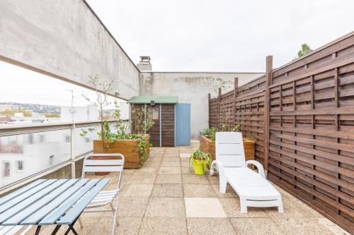 un patio con 2 sillas y un banco en el balcón en GuestReady - Studio Gerland neuf avec terrasse, en La Mulatière