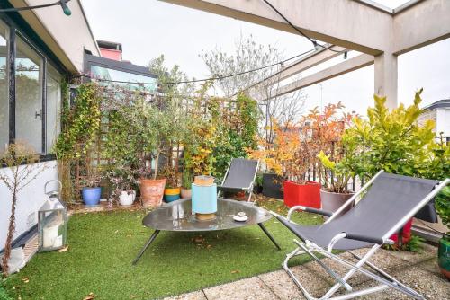 un patio avec une table, des chaises et des plantes dans l'établissement GuestReady - Apt confortable avec terrasse au 18e, à Paris