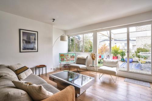 un salon avec un canapé et une table dans l'établissement GuestReady - Apt confortable avec terrasse au 18e, à Paris