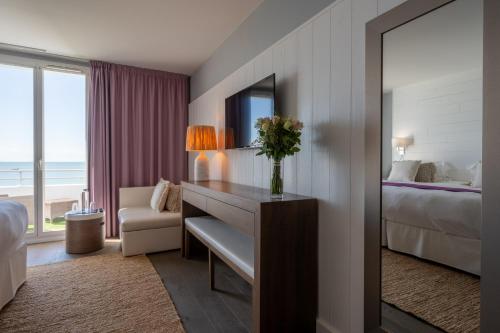 a hotel room with a desk and a bed and a window at Hôtel Atalante - Relais Thalasso & Spa in Sainte-Marie-de-Ré