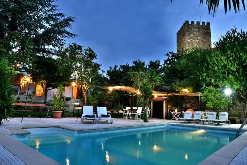 a pool with chairs and a building in the background at Douro Mool Guest House in Lamego