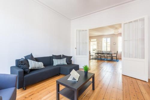 un salon avec un canapé bleu et une table dans l'établissement GuestReady - Duplex lumineux et spacieux, 7 personnes, à Bordeaux