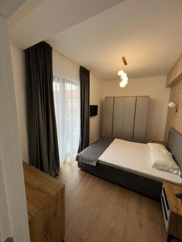 Un dormitorio con una cama y una ventana grande. en sicanT Apartments - Self Check-in, en Constanţa