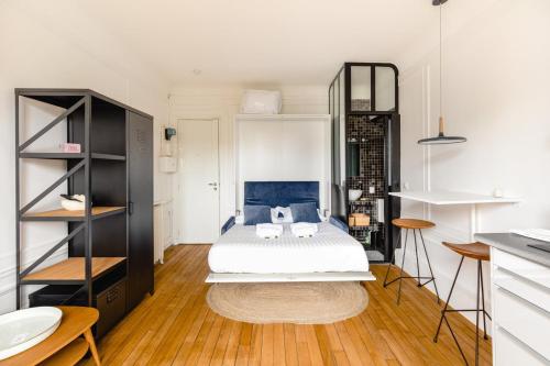 une chambre avec un lit blanc et un parquet dans l'établissement GuestReady - Fantastic studio near Sacré-Cœur, à Paris