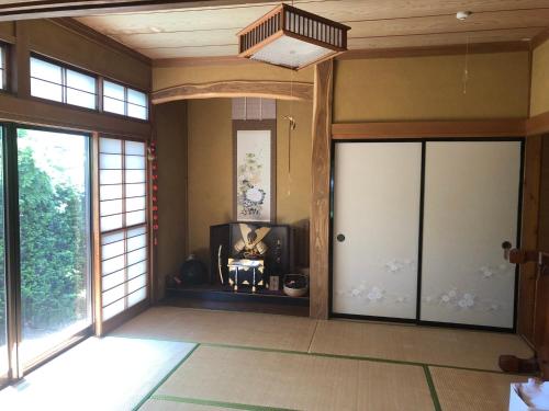an empty room with two doors and a balcony at 民宿とまとハウスTomato House in Funehiki