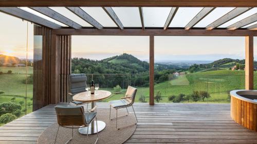 a room with a deck with a table and chairs at steiRerBLiCke - Winzerhäuser an der südsteirischen Weinstraße in Glanz an der Weinstraße 
