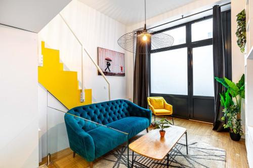 un salon avec un canapé bleu et une table dans l'établissement Disponible - Paris - All Equipped Souplex - From 1 to 6 Guests - Entry from 3pm - Departure up to 11am, à Paris