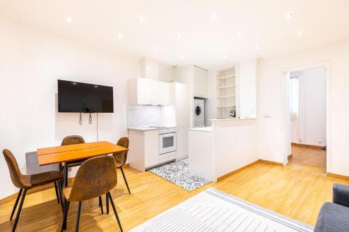 une cuisine et une salle à manger avec une table et des chaises dans l'établissement GuestReady - Lovely Parisian Apartment for 4pax., à Paris