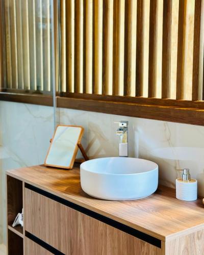 a bathroom with a white sink on a wooden counter at REMANSO DE TRASFONTAO Casa das Árbores & Bubble in Silleda