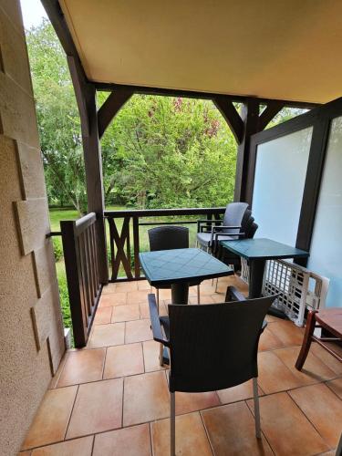 - une véranda avec des tables et des chaises dans l'établissement Résidence du Golf, Deauville, à Deauville