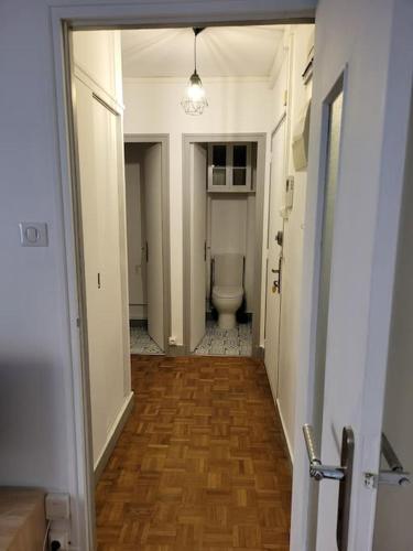 - un couloir menant à une salle de bains pourvue de toilettes dans l'établissement Appartement en résidence - centre ville de Limoges, à Limoges