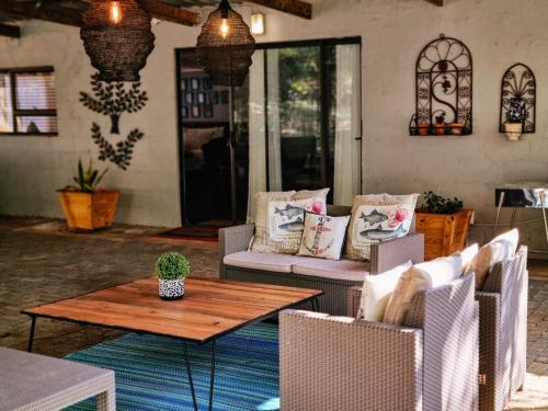 a patio with chairs and a wooden table and a table and chairs at Winterton Country Lodge @ Rose Cottage in Winterton