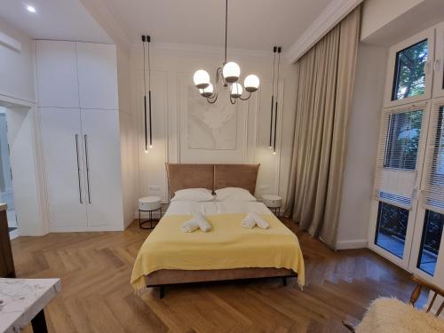 a bedroom with a large bed and a chandelier at Apartamenty Inspiracja in Kraków
