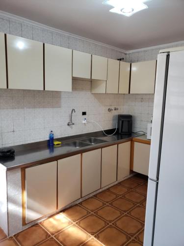 a kitchen with white cabinets and a sink at Pousada Monte Gerizim in Sao Paulo