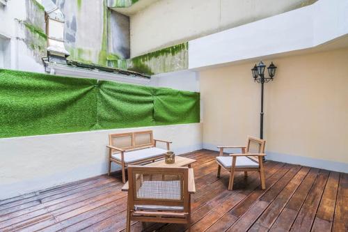d'une terrasse avec des chaises, une table et un mur vert. dans l'établissement Studio avec terrasse #SacréCœur #Montmartre, à Paris
