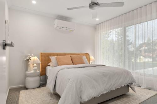 ein weißes Schlafzimmer mit einem Bett und einem Fenster in der Unterkunft Chic Coastal Retreat 3 Bdr Close to Beach in Cowes