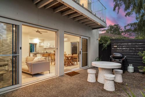 Ein Haus mit einer Terrasse mit einem Tisch und einem Esszimmer in der Unterkunft Chic Coastal Retreat 3 Bdr Close to Beach in Cowes