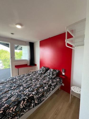 - une chambre dotée d'un lit avec un mur rouge dans l'établissement JOIA Bassin d'Arcachon - NOTRO 221, à La Teste-de-Buch