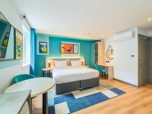 a bedroom with a bed and a blue wall at Holyrood Aparthotel in Edinburgh