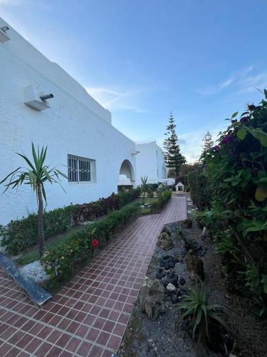 a brick walkway in front of a white building at Villa Vue sur la Méditerranée in Cabo Negro