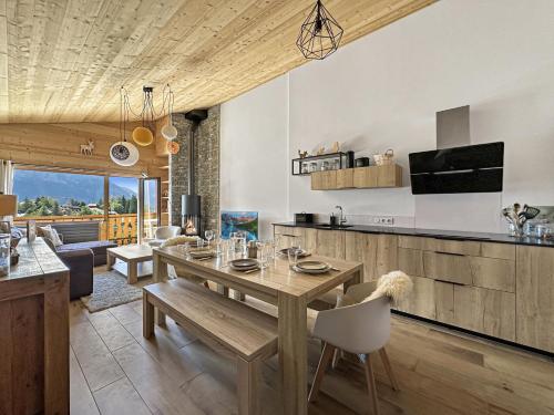 Il dispose d'une cuisine et d'un salon avec une table et des chaises en bois. dans l'établissement GR450 6 Pers Centre Carroz, aux Carroz d'Arâches