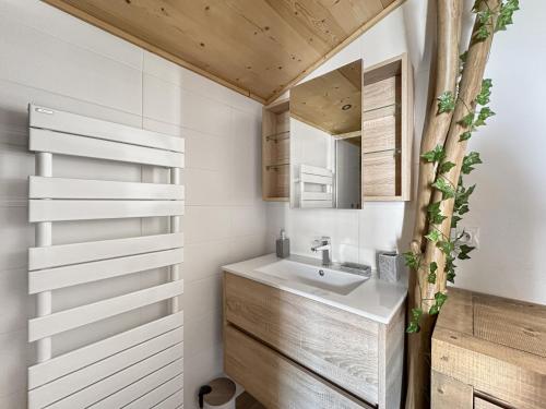 une salle de bain avec un lavabo et un miroir dans l'établissement GR450 6 Pers Centre Carroz, aux Carroz d'Arâches