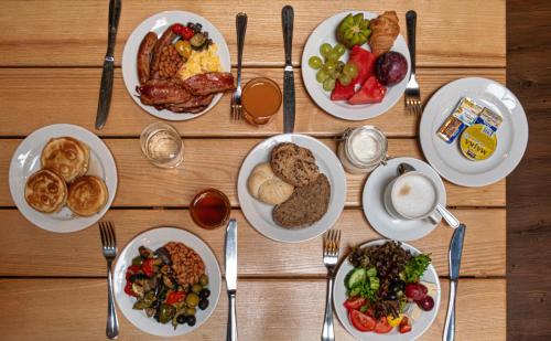 a wooden table topped with plates of breakfast food at Hotel "Palác U Kočků" by Adrez, Palace At the Cats in Prague