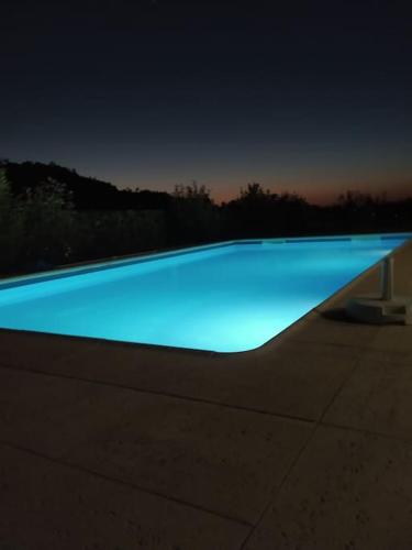 a swimming pool with blue water at night at Coura Lodge in Paredes de Coura