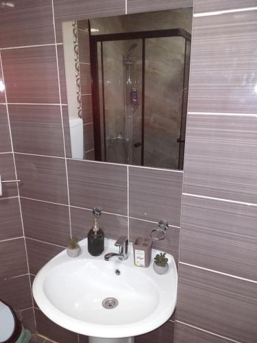 a bathroom with a sink and a mirror at City view & pool apartment in Niš