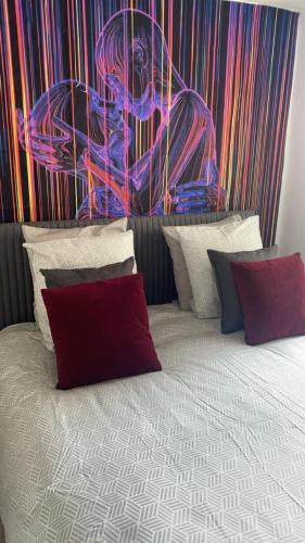 une chambre avec un lit avec un tableau sur le mur dans l'établissement HYPER CENTRE, REMPARTS, VIEILLE VILLE , COSY, possible tout faire à pieds, à Boulogne-sur-Mer