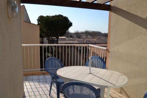 un patio avec une table et des chaises sur un balcon dans l'établissement 030 Jean Bart 54, au Cap d'Agde