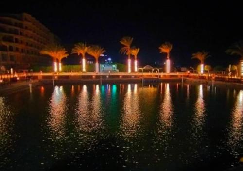 a large body of water with palm trees at night at Davinci Beach Resort in Hurghada