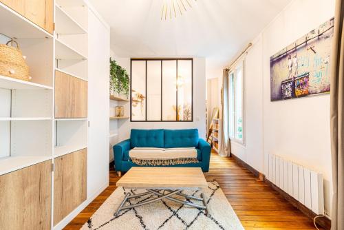 un salon avec un canapé bleu et une table dans l'établissement GuestReady - Amazing 1BDR App in 18th ARR., à Paris