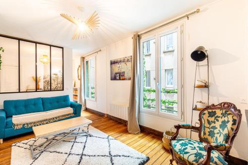 un salon avec un canapé bleu et une chaise dans l'établissement GuestReady - Amazing 1BDR App in 18th ARR., à Paris