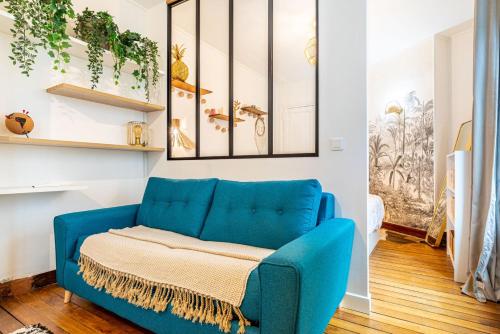 - un canapé bleu dans un salon orné de plantes dans l'établissement GuestReady - Amazing 1BDR App in 18th ARR., à Paris