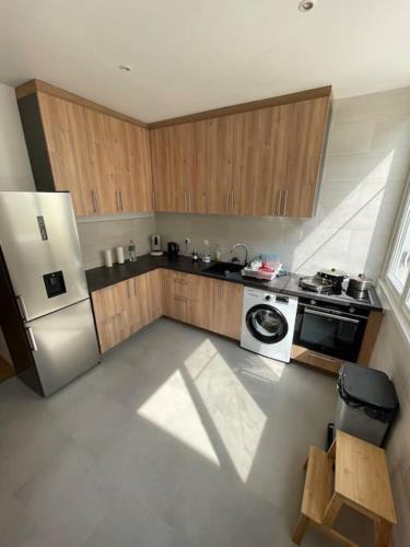 une cuisine avec des armoires en bois et un réfrigérateur blanc dans l'établissement Élégante Maison proche de la Mer, au Tréport