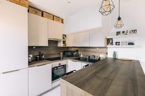 une cuisine avec des armoires blanches et un comptoir en bois dans l'établissement GuestReady - Appartement de charme au dernier étage, à Paris