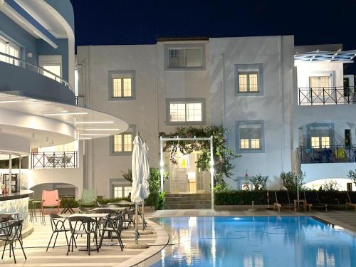 a hotel with a swimming pool in front of a building at Evdokia Suites in Gouves