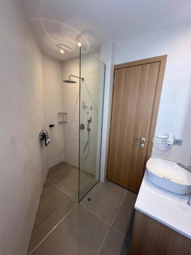 a bathroom with a shower and a toilet and a glass door at Evdokia Suites in Gouves
